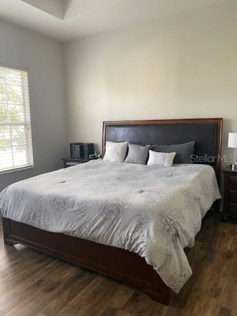 bedroom with dark hardwood / wood-style flooring