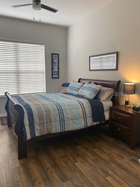 bedroom with dark hardwood / wood-style floors and ceiling fan