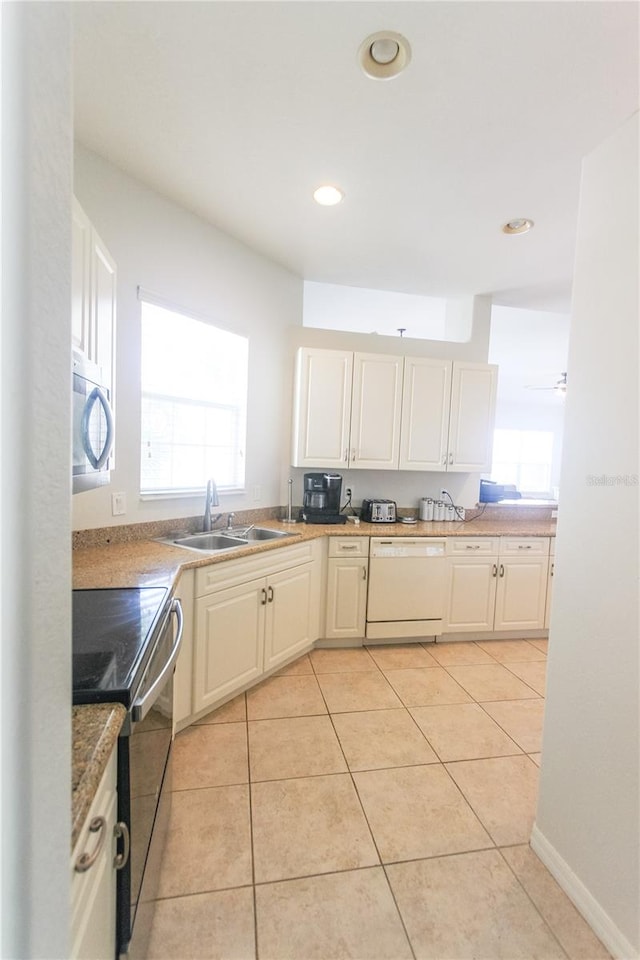 kitchen with dishwasher, stove, sink, ceiling fan, and light tile patterned flooring