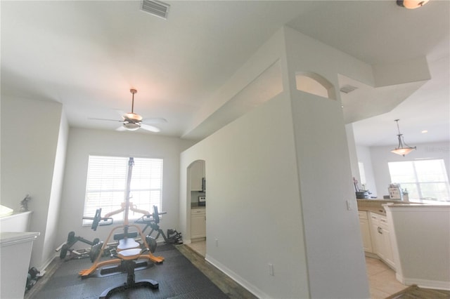 workout room with ceiling fan, a healthy amount of sunlight, and light hardwood / wood-style floors