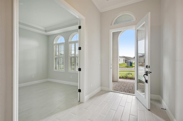 foyer featuring ornamental molding, light hardwood / wood-style floors, and a wealth of natural light