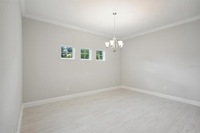 spare room with ornamental molding, an inviting chandelier, and light hardwood / wood-style flooring