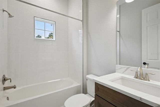 full bathroom with tiled shower / bath, vanity, and toilet