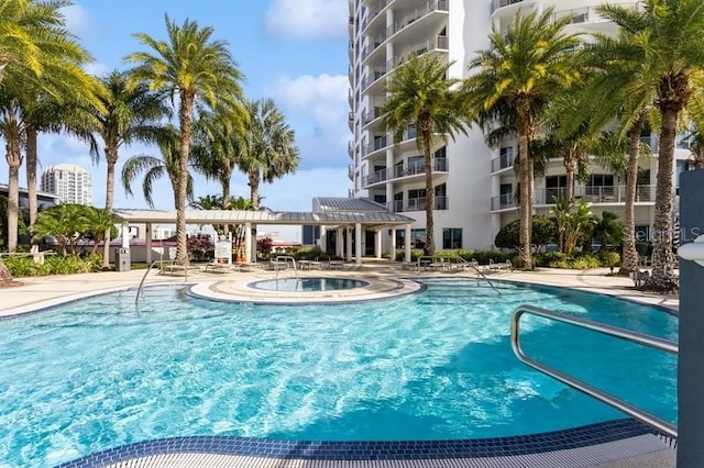 view of swimming pool featuring a hot tub