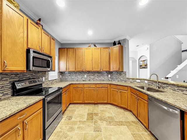 kitchen featuring light stone countertops, appliances with stainless steel finishes, crown molding, and sink