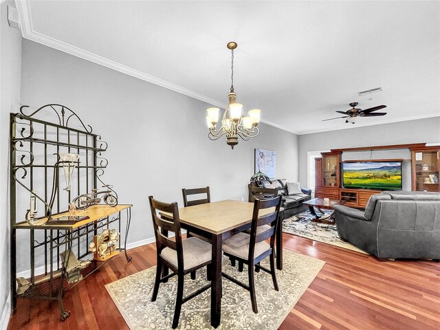 dining space featuring hardwood / wood-style floors, ceiling fan with notable chandelier, and ornamental molding