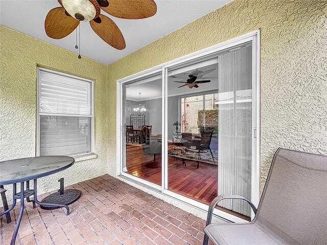 sunroom / solarium with ceiling fan with notable chandelier