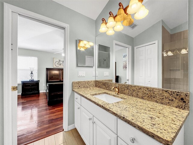 bathroom with tile patterned flooring, vanity, ceiling fan, and lofted ceiling