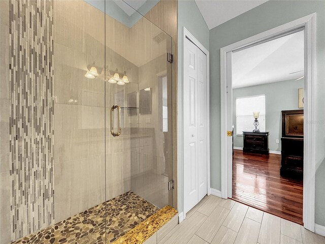 bathroom featuring vaulted ceiling and a shower with shower door