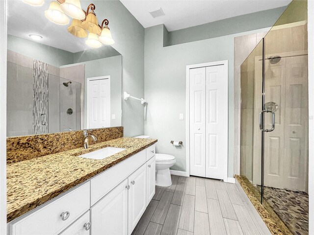 bathroom with walk in shower, vanity, and toilet