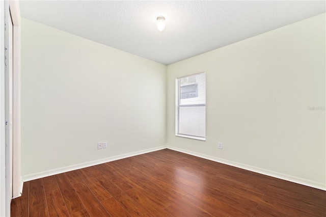 unfurnished room with hardwood / wood-style floors and a textured ceiling