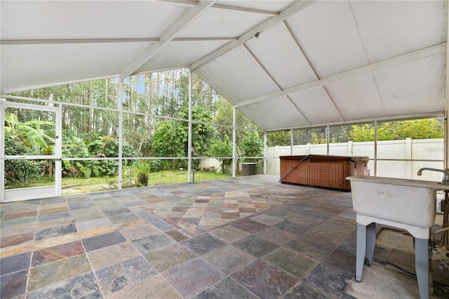 unfurnished sunroom with vaulted ceiling with beams