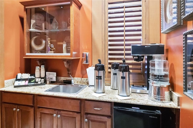 bar featuring light stone counters and sink