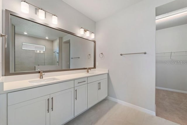 bathroom with tile patterned floors, a shower, and vanity