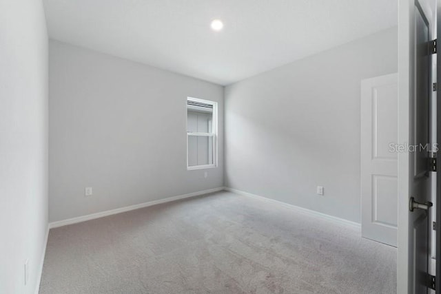 unfurnished room featuring light carpet