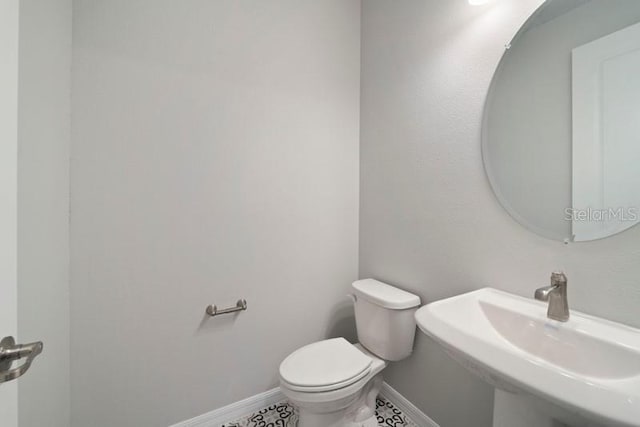 bathroom with tile patterned flooring, toilet, and sink