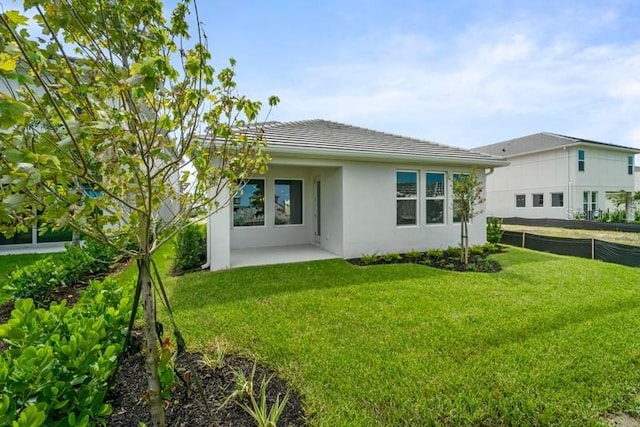 back of property with a yard and a patio area