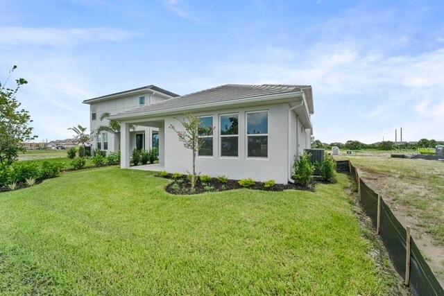 back of house with a lawn and a patio area