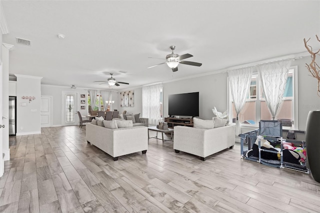 living room with light wood-type flooring, ceiling fan, and crown molding