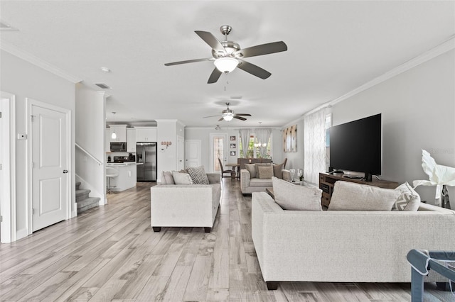 living room with light hardwood / wood-style flooring, ceiling fan, and ornamental molding