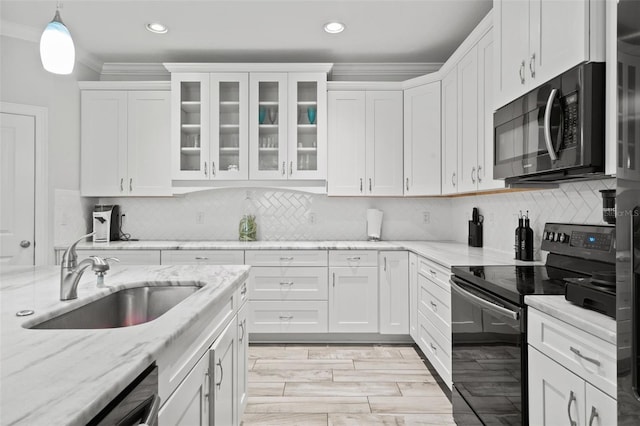 kitchen featuring crown molding, white cabinetry, decorative light fixtures, sink, and black range with electric stovetop