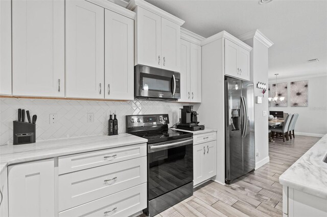 kitchen featuring light hardwood / wood-style flooring, stainless steel appliances, white cabinetry, tasteful backsplash, and ornamental molding