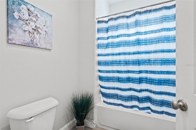 bathroom featuring toilet and shower / bath combo with shower curtain