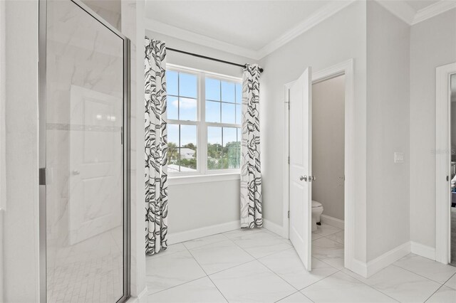 bathroom featuring ornamental molding, toilet, and an enclosed shower