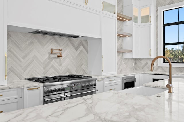 kitchen with range with two ovens, white cabinetry, and light stone countertops