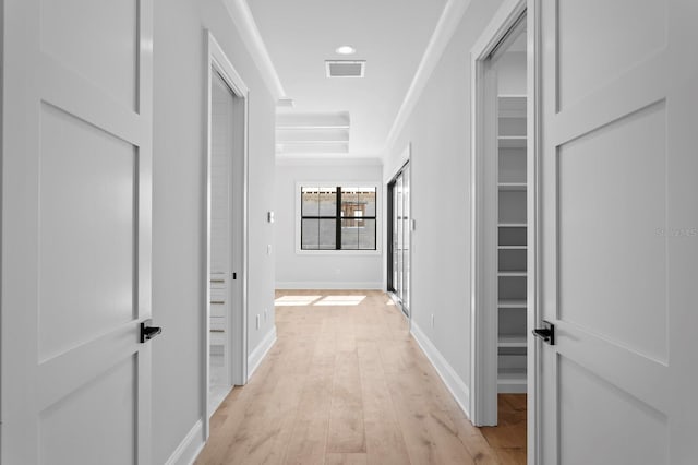 hall featuring ornamental molding and light hardwood / wood-style flooring