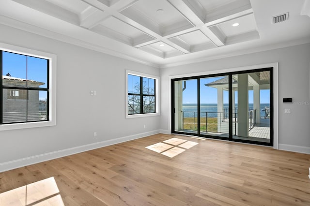 unfurnished room with coffered ceiling, light hardwood / wood-style flooring, beamed ceiling, and a water view