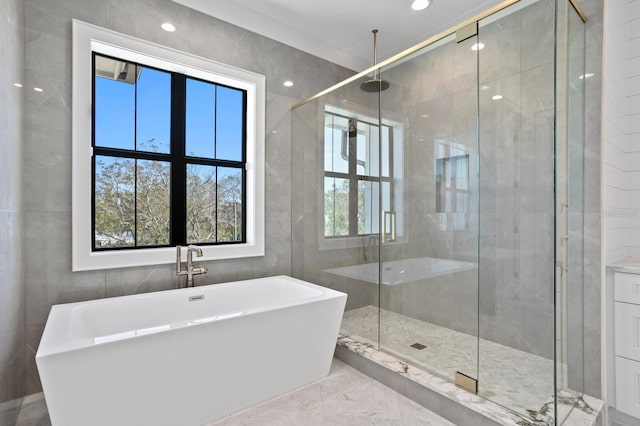bathroom featuring tile walls and separate shower and tub