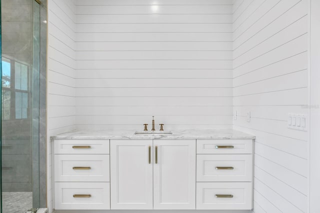 bathroom featuring walk in shower and vanity