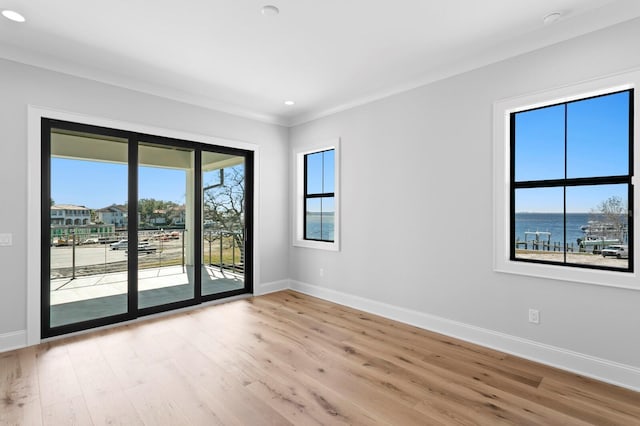 empty room with a water view and light hardwood / wood-style floors