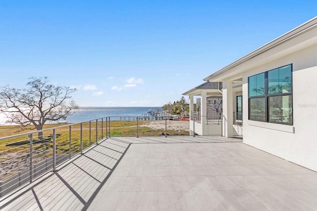 view of patio with a water view and a balcony