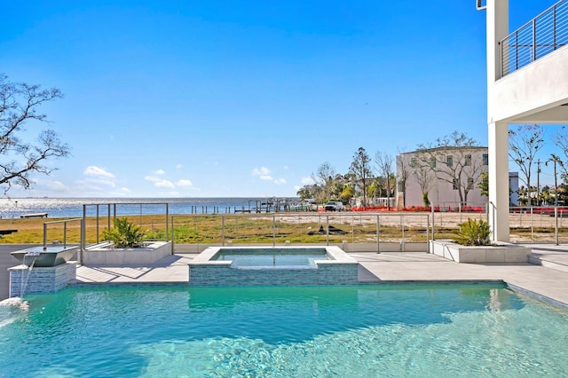 view of swimming pool featuring an in ground hot tub, a water view, and a patio area