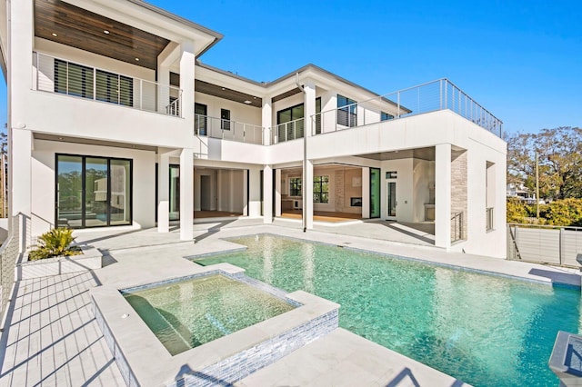 back of property with a pool with hot tub and a patio