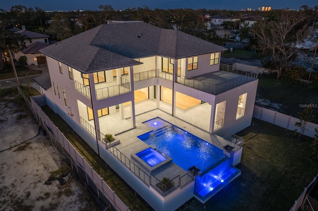 exterior space with a pool with hot tub, a balcony, a patio, and pool water feature