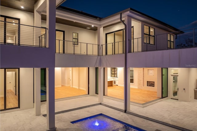 rear view of house with a jacuzzi and a patio area