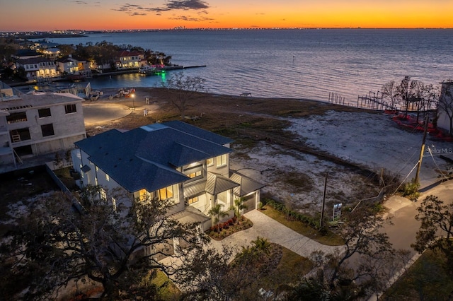 aerial view at dusk featuring a water view