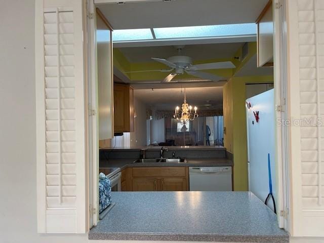 kitchen with ceiling fan with notable chandelier, sink, and white appliances