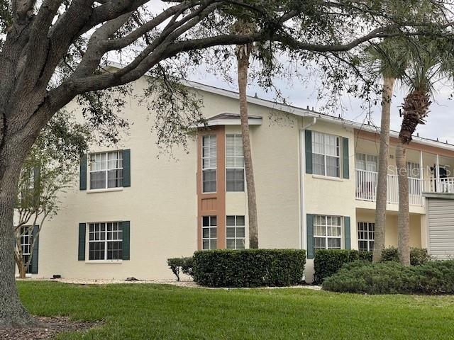 view of home's exterior with stucco siding and a lawn