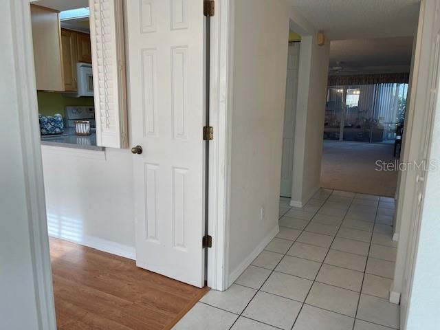 hallway featuring light tile patterned flooring and baseboards