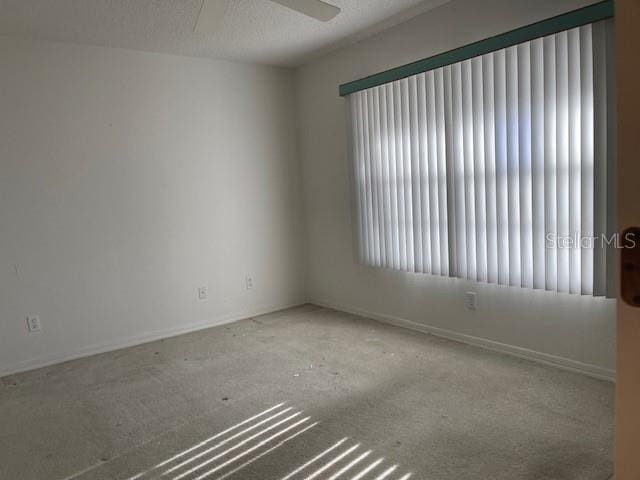 carpeted spare room with ceiling fan