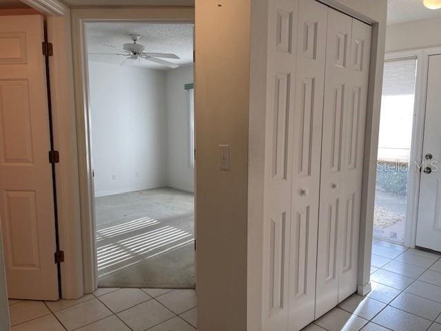 hallway featuring light carpet and light tile patterned flooring