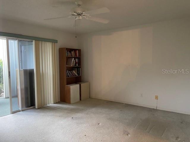 empty room with ceiling fan and light carpet