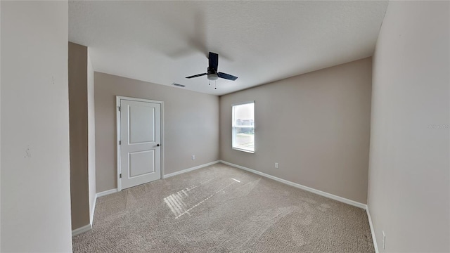 carpeted spare room with ceiling fan