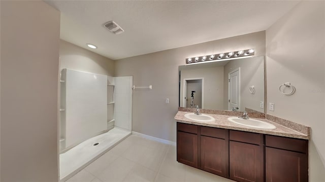 bathroom with tile patterned floors, vanity, and walk in shower