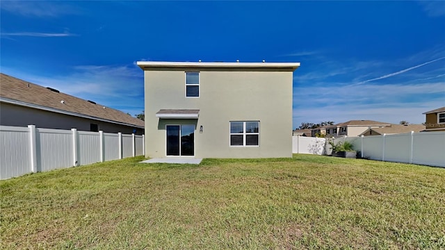 rear view of property featuring a lawn