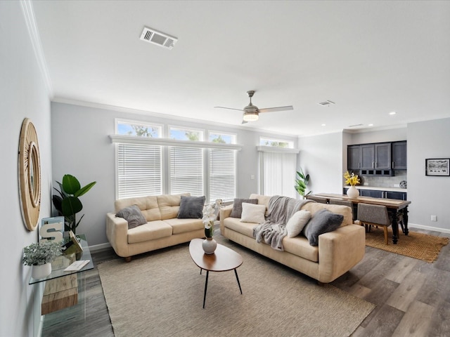 living room featuring hardwood / wood-style floors, ceiling fan, and ornamental molding